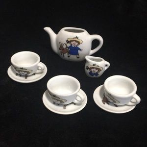 Miniature porcelain child’s tea set. Includes pitcher, creamer, 3 cups w/saucers
